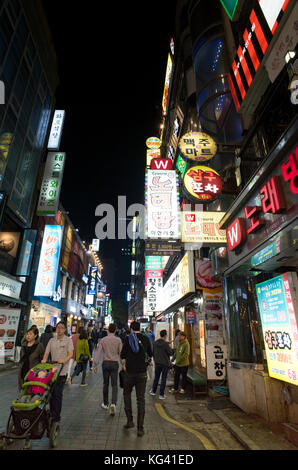 Hell erleuchtet mit Leuchtreklamen der arbeitsreichen Nacht Zeit Straßen im Zentrum von Seoul voller Bewohner und Touristen, die Restaurants und Bars Stockfoto