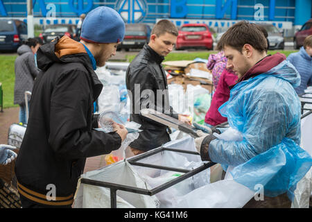 Die Freiwilligen sammeln Hausmüll für das Recycling in einem Platz in der Stadt der Provinz zheleznodorozhny, Moskau, Russland. Die lokalen Bewohner haben ihre Abfälle im Voraus zu Hause in den letzten Wochen sortiert und können es in separaten Beuteln oder Container hier verlassen, für den Weitertransport und anderswo Recycling. für jetzt, die Freiwilligen hier einmal im Monat kommen, aber die Idee gewinnt an Popularität. Abfall Sortierung ist noch in Russland, wo etwa 90 Prozent der Hausmüll bis zu riesigen, offenen Müllhalden endet selten. Stockfoto