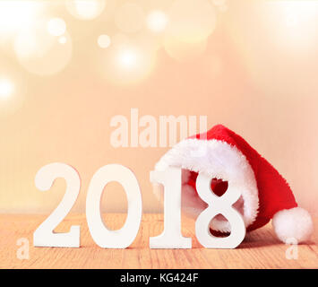 Santa Pelzkappe auf einem rustikalen Holzmöbeln Hintergrund mit Zahlen 2018 Stockfoto
