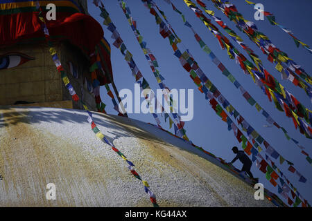 Kathmandu, Nepal. November 2017. An einem glückverheißenden Tag in Kathmandu, Nepal, am Freitag, den 03. November 2017, geht ein Mann auf die Kuppel, um Gebetsfahnen rund um die Boudhanath Stupa zu schmücken. Quelle: Skanda Gautam/ZUMA Wire/Alamy Live News Stockfoto