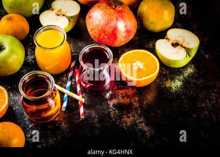 Frisches Obst und Säfte. Orangen-, Granatapfel- und Äpfel. Dunkle Rusty Hintergrund Kopie Raum Stockfoto