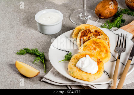 Veganes essen. Käse Kartoffelpüree Kartoffelpuffer, Koteletts mit Dill und Sauerrahm. Am grauen Stein Hintergrund Kopie Raum Stockfoto