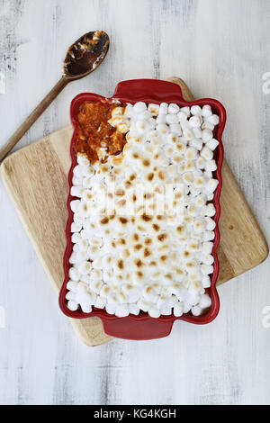 Overhead shot von Kartoffel Auflauf gebacken mit mini Marshmallows für thanksgiving Tag bereit. ein Stück fehlt in der Ecke. Schuss von oben. Stockfoto