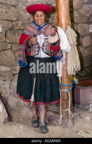 Frau in traditionellen peruanischen Kleidung macht Garn aus Alpaka und Lama wolle in der Nähe von Cusco, Peru Stockfoto