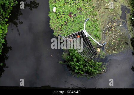 Ein verlassener Einkaufswagen, der in einem lokalen Fluss abgeladen wurde und Umweltschäden in Bristol, England, Großbritannien, verursachte Stockfoto