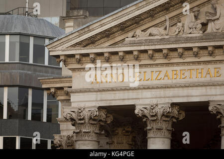 Lateinische Inschriften über Spalten mit korinthischen Kapitellen der Cornhill im Herzen der Square Mile, historischen und finanziellen Zentrum der Hauptstadt, am 1. November 2017, in der City von London, England. An der Spitze der Dorischen und ionischen Säulen mit kunstvollen Steinmetzarbeiten, kraftvoll starke Fensterstürze Kreuz, mit der Last der bildenden Kunst und Schnitzereien, welche Funktion das Design von Sir William Tite in 1842-1844 und 1844 geöffnet von Königin Victoria, dessen Name in lateinischen (VICTORIAE R) geschrieben wird. Stockfoto