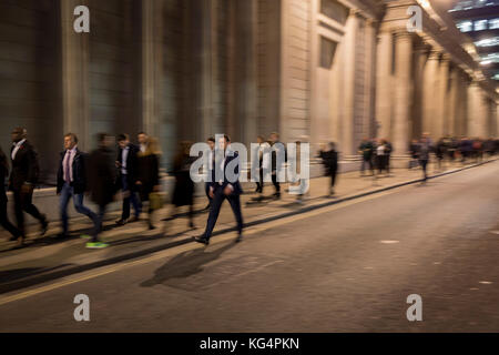 Verschwommen Pendler Spaziergang entlang der Threadneedle Street, unterhalb der Wände und Säulen der Bank von England im Herzen der Square Mile, historischen und finanziellen Zentrum der Hauptstadt, am 1. November 2017, in der City von London, England. Stockfoto