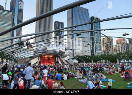 Millennium Park, Masse am Grant Park Symphony den Jay pritzker Pavilion, einer Konzertmuschel, entworfen von Frank Gehry, Hochhäuser der Innenstadt auf der Rückseite Stockfoto