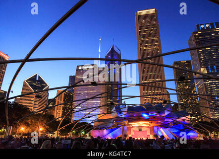 Millennium Park, Masse am Grant Park Symphony den Jay pritzker Pavilion, einer Konzertmuschel, entworfen von Frank Gehry, Hochhäuser der Innenstadt auf der Rückseite Stockfoto