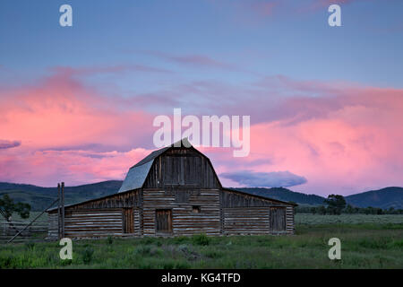 Wy 02543-00 ... Wyoming - dramatischer Sonnenuntergang Farben nach einem Regen Sturm über eine historische bsrn an einem alten Gehöft auf der Mormonen Zeile im Grand Teton National Park. Stockfoto