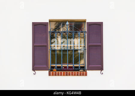 Fenster mit Fensterläden und Schmiedeeisen Gitter auf die weiße Fassade Vorderansicht Stockfoto
