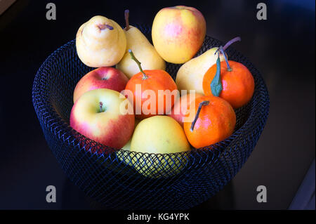 Schwarze Früchte Korb mit Äpfeln, Birnen und Mandarinen Stockfoto