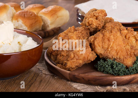 Gebratenes Huhn auf einer Servierplatte mit Kartoffelpüree und Rollen Stockfoto