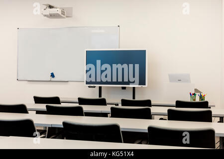 Moderne Klassenzimmer Interieur, mit White Board, Schreibtischen und Stühlen. Stockfoto