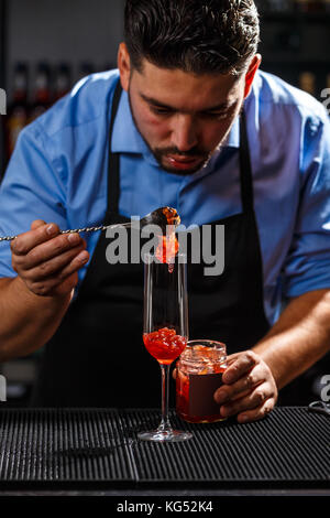 Barkeeper cocktail vorbereiten mit Rose jam Stockfoto