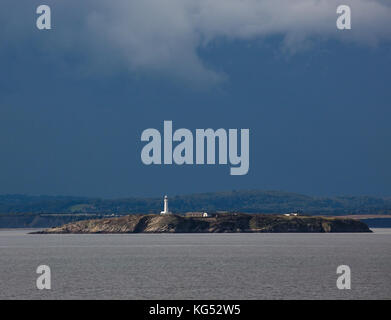 Flat Holm Insel und Leuchtturm in der Bristol Kanal zwischen South Wales und die Somerset Küste mit dramatischen Sturmwolken über der walisischen Küste Stockfoto