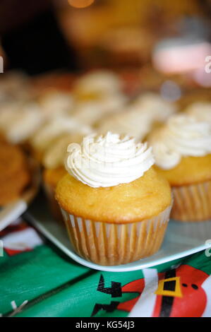 Close-up Frosted, verzierte Cupcakes, vergoldet, auf einem Tisch in einer Gemeinschaft oder Familienfeier. Stockfoto