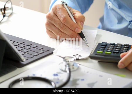 Healthcare Kosten und Gebühren Konzept. Hand von smart Arzt ein Rechner für medizinische Kosten in modernen Krankenhaus verwendet werden Stockfoto