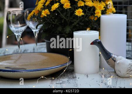 Tabelle mit Kerzen Keramik, Weingläser, Chrysantheme Pflanzen dekoriert Stockfoto