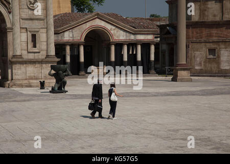 Ein Mann und eine Frau, die zu Fuß über die Römischen set an der Cinecittà Filmstudios in Rom, Italien. Stockfoto