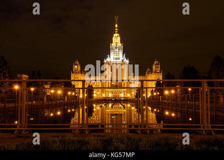 Eine schöne Nacht Blick von Moskau mit dem Hauptgebäude der Moskauer Staatlichen Universität, Beleuchtung und Reflektionen im Wasser durch den Metallzaun der Stockfoto