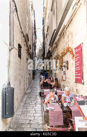 Menschen essen in einem Restaurant in der schmalen Straße in Dubrovnik, Kroatien Stockfoto