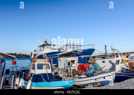 Angedockt bunte Boote und Angelausrüstung sind mit Seilen auf dem Moor am lokalen Port gebunden. Stockfoto