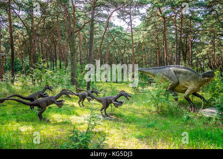 Solec kujawski, Polen - August 2017: Leben große Gruppe von Raptor Dinosaurier Statuen in einem Wald Stockfoto