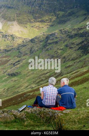 Senior paar mit Blick auf ein Tal im Nationalpark Lake District, Cumbria, Großbritannien Stockfoto