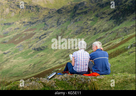 Senior paar mit Blick auf ein Tal im Nationalpark Lake District, Cumbria, Großbritannien Stockfoto