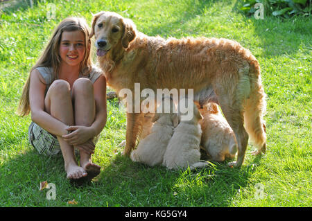 Mädchen mit Golden Retriever und Hund Welpen im Garten Stockfoto