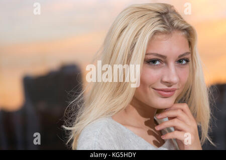 Junge Frau, blond, Lächeln, in die Kamera schaut, Porträt Stockfoto