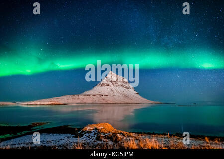Aurora Borealis oder Nordlichter mit der Milchstraße über Fjord. Mt. Kirkjufell, Grundarfjordur, Snaefellsnes Peninsula, Island Stockfoto