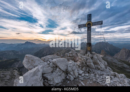 Sexten, Provinz Bozen, Dolomiten, Südtirol, Italien. Das Gipfelkreuz am Paterno im Sonnenuntergang Stockfoto