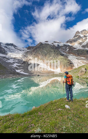 Ein Mädchen sieht die Locce See und die Grober Gletscher am Fuße der Ostwand des Monte Rosa Massivs (Locce See, Macugnaga, Anzasca Valley, Provinz Verbano Cusio Ossola, Piemont, Italien, Europa) Stockfoto