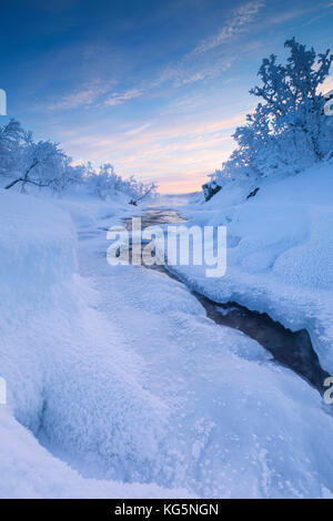 Sonnenaufgang auf dem gefrorenen Fluss, abisko, Norrbotten County, Gemeinde Kiruna, Lappland, Schweden Stockfoto