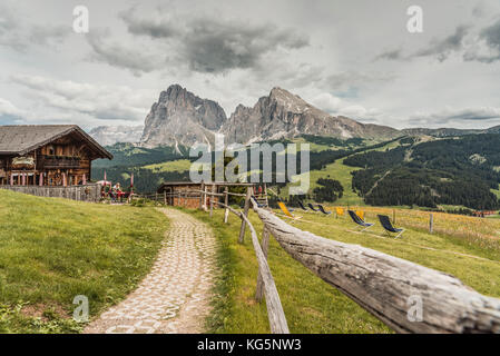 Seiser Alm, Dolomiten, Südtirol, Italien. Blick von der Seiser Alm auf die Gipfel Langkofel und Plattkofel mit Rauch Hütte auf der linken Seite Stockfoto