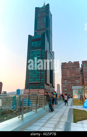 Kaohsiung, Taiwan. Menschen neben dem Tuntex Sky Tower den Sonnenuntergang beobachten. Die Struktur ist 378 m hoch. Von 1994 bis 1997 gebaut, es ist das höchste Hochhaus in Kaohsiung, und war die höchste in Taiwan bis zur Fertigstellung des Taipei 101. Stockfoto