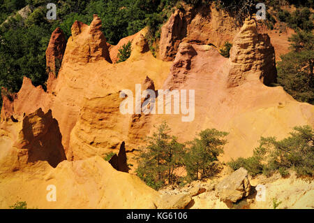 Ockerklippen und Bäume in Colorado Provence, Rustrel, Vaucluse, Frankreich Stockfoto