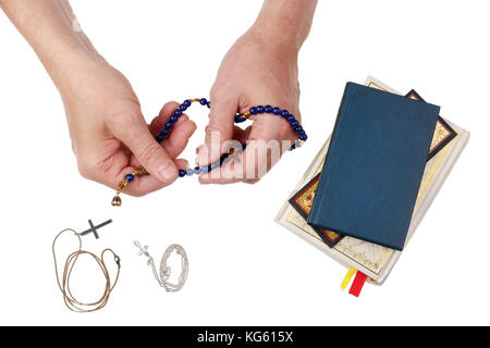 Ein älterer Mann betet für die Gesundheit seiner Familie zu Gott. in seinen Händen hält er Achat Perlen. Auf dem Tisch liegen die Bibel und Silber Kreuze. Isolierte o Stockfoto
