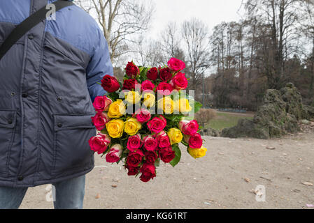 Bündel Rosen in der Hand an einem Ausländer Straßenhändler. Beispiel eines bescheidenen funktionieren und wie sie in einem einfachen, aber ehrlichen Weg zu leben Stockfoto