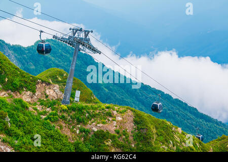 Die Seilbahn auf dem Hintergrund der Bergrücken und Berghänge in Rosa Khutor, Russland Stockfoto