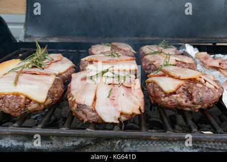 Burger mit Speck gegrillt auf dem Grill, Stockfoto