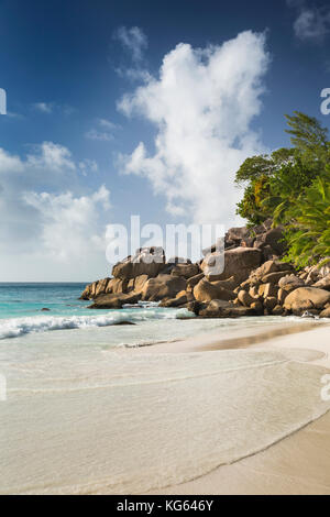 Die Seychellen, Praslin, Anse Georgette, Strand Mann saß auf den Felsen am Strand Stockfoto