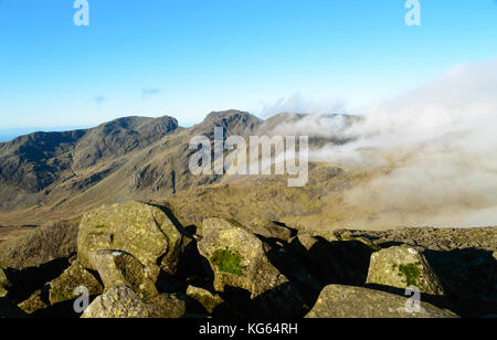 Scafell Pike und scafell aus bowfell im englischen Lake District im Clearing Nebel. Stockfoto