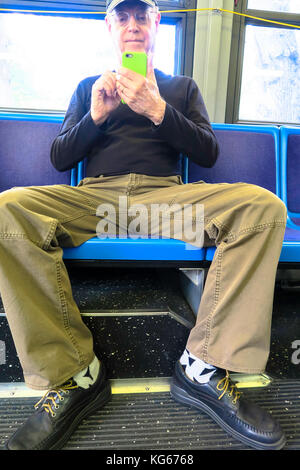 Mann in Beschlag nehmen mehr als einen Sitz (man verbreiten) auf New York City Bus, NYC, USA Stockfoto