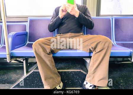 Mann in Beschlag nehmen mehr als einen Sitz (man verbreiten) auf New York City Bus, NYC, USA Stockfoto