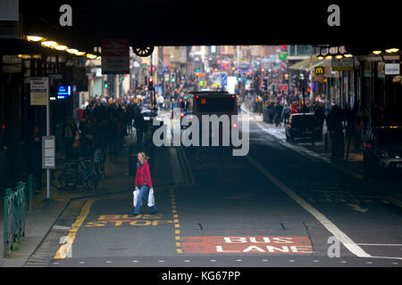 Hauptbahnhof highlanders Regenschirm Argyle Street Glasgow Verkehr und Fußgänger bus Lane Bushaltestelle Stockfoto