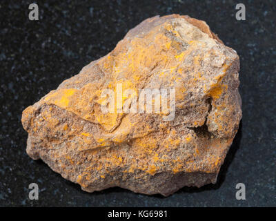 Makroaufnahmen von natürlichen Mineralgestein Muster - grobe Limonit Stein auf dunklem Granit Hintergrund aus olkhinskoye Mine, Irkutsk Region, Russland Stockfoto