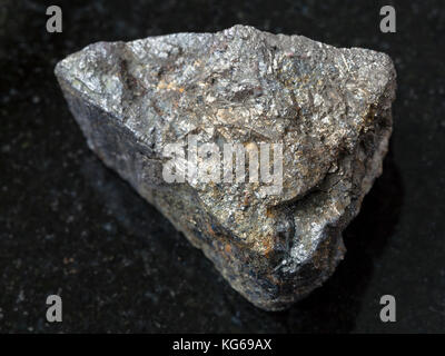 Makroaufnahmen von natürlichen Mineralgestein Muster - raw Arsenopyrit Stein auf dunklem Granit Hintergrund aus zabaykalsky Krasnodar, Russland Stockfoto